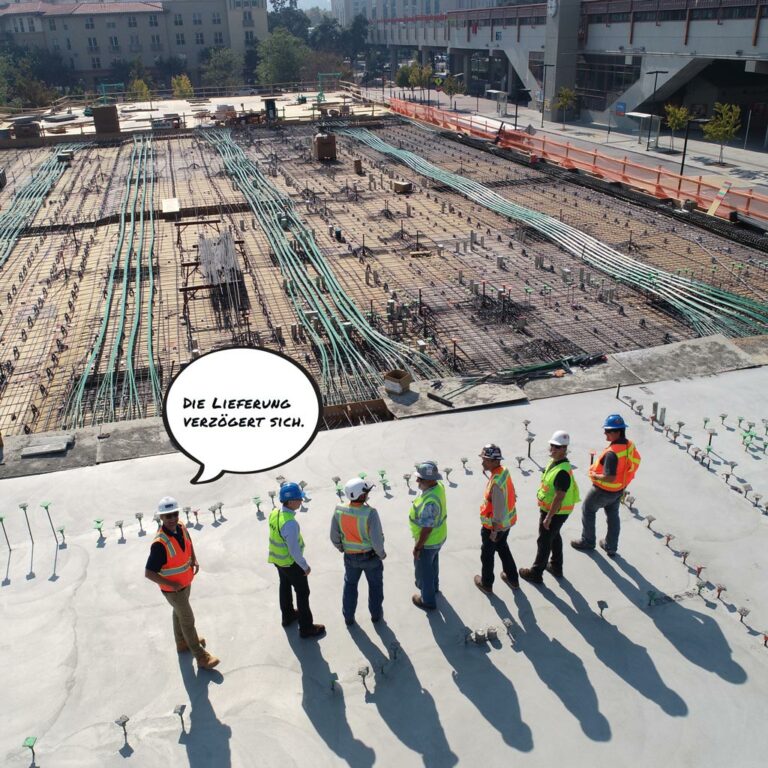 Bauarbeiter stehen vor einer Baustelle: Eine Lieferung verzögert sich